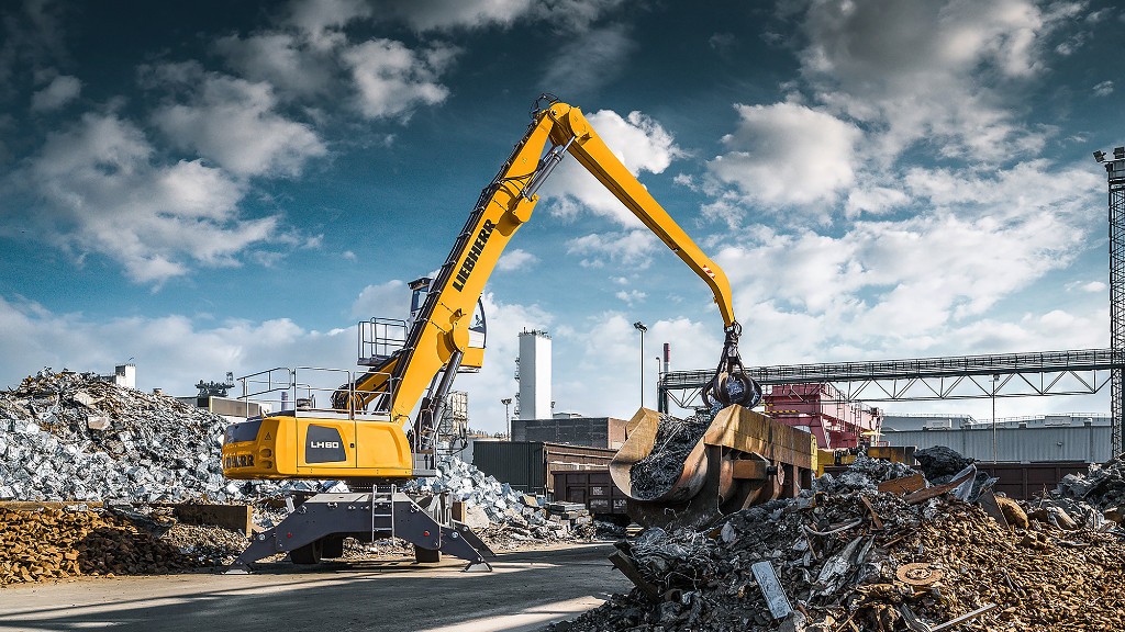 A material handler lifts scrap metal in a scrapyard