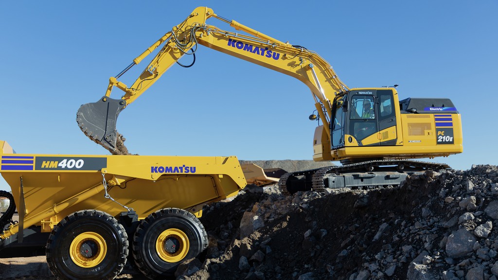 An excavator on a pile loading an articulated dump truck.