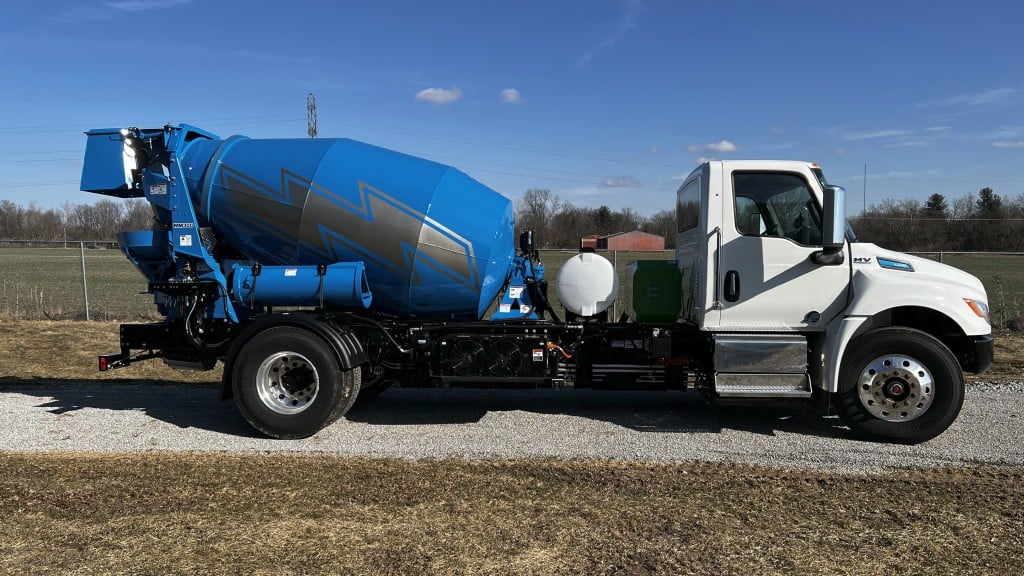 An all-electric mixer is parked on a gravel road