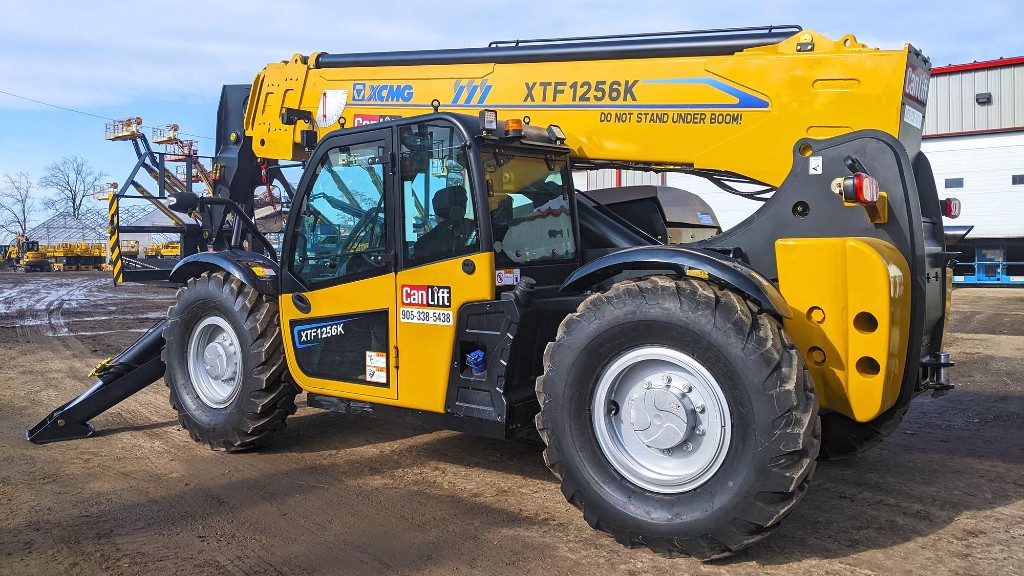 A telehandler is parked in a dirt parking lot