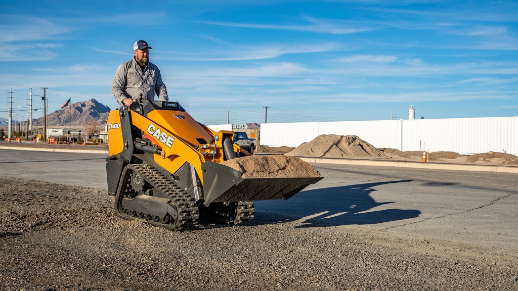 A worker operating a mini track loader.