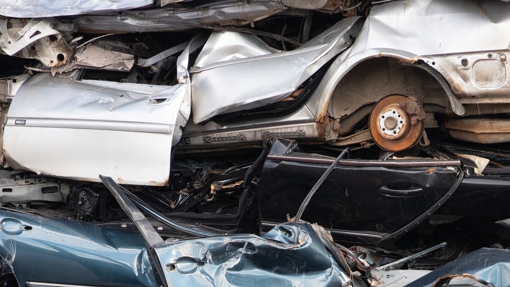 Squished cars are stacked in a pile