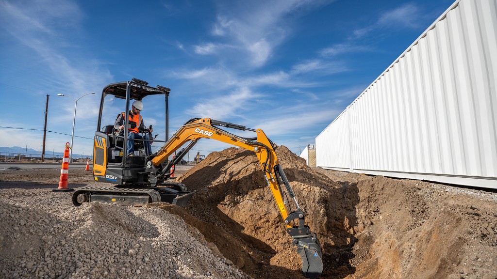 A mini excavator working near a house