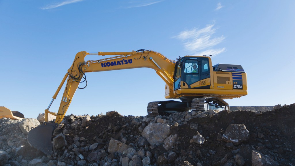 An excavator with its bucket about to pick up a load of rocks