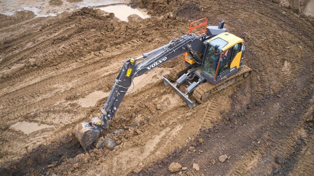 An excavator digs a trench on a job site
