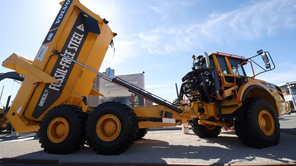 An articulated hauler is parked outside at a trade show