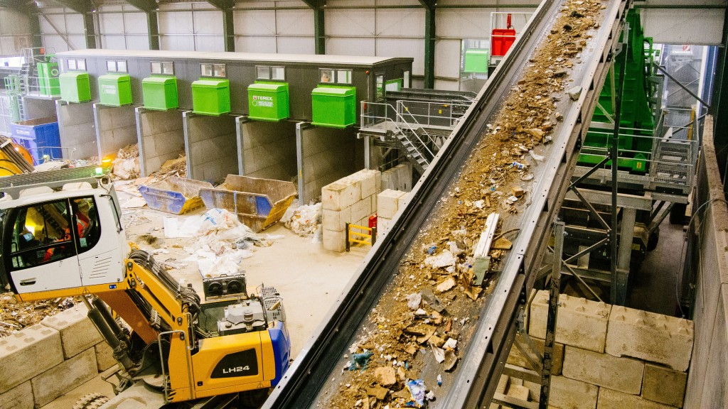 C&D waste travles up a conveyor in a facility