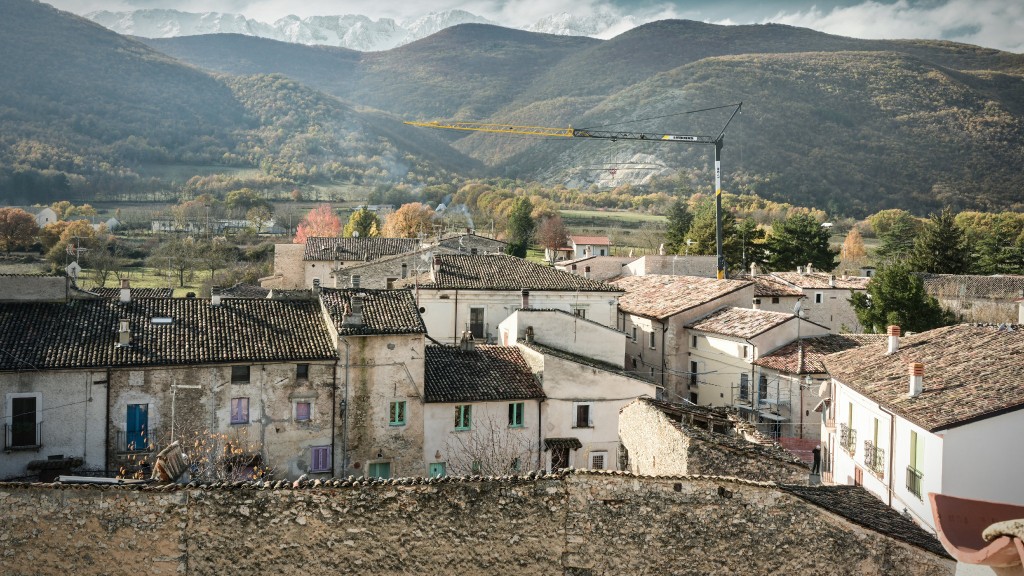 A tower crane operates high above an Italian town