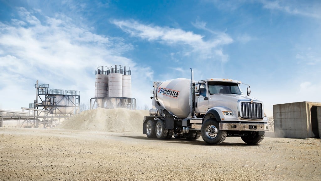 A concrete mixer driving across a work site.