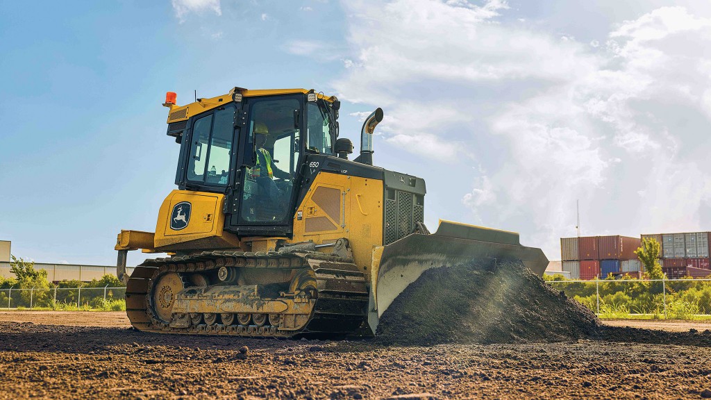 A dozer pushes dirt on flat ground in a job site.