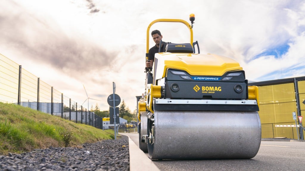 A tandem roller compacts asphalt on a road-in-progress