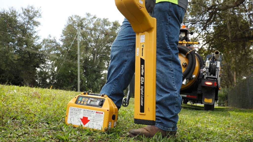 A worker uses a utility locator on a residential job site