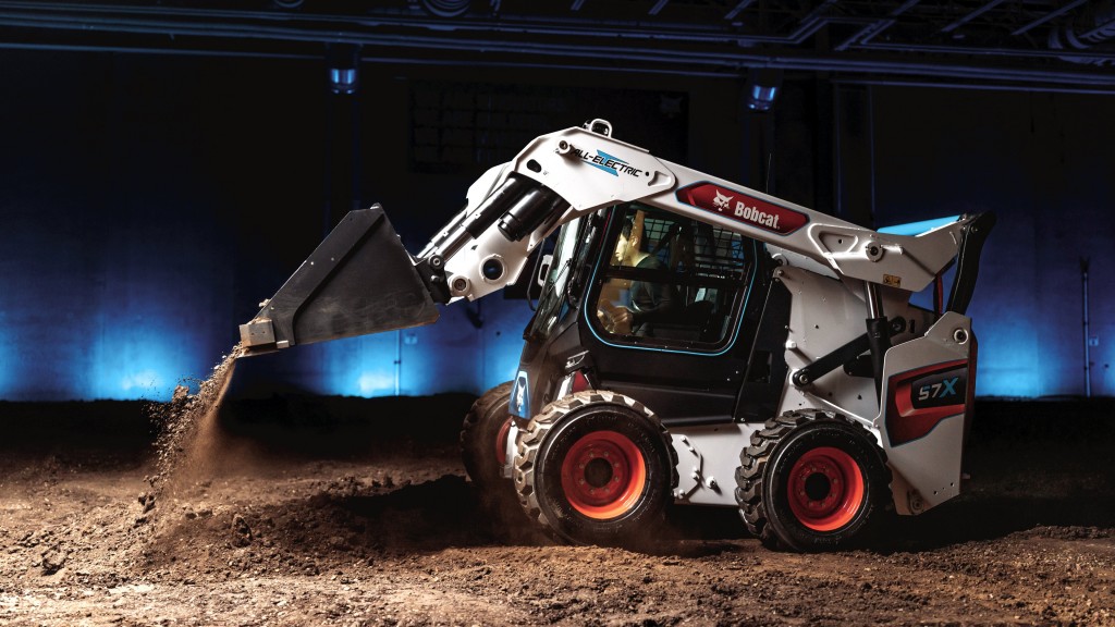 A skid-steer loader dumps a bucket of dirt on the job site