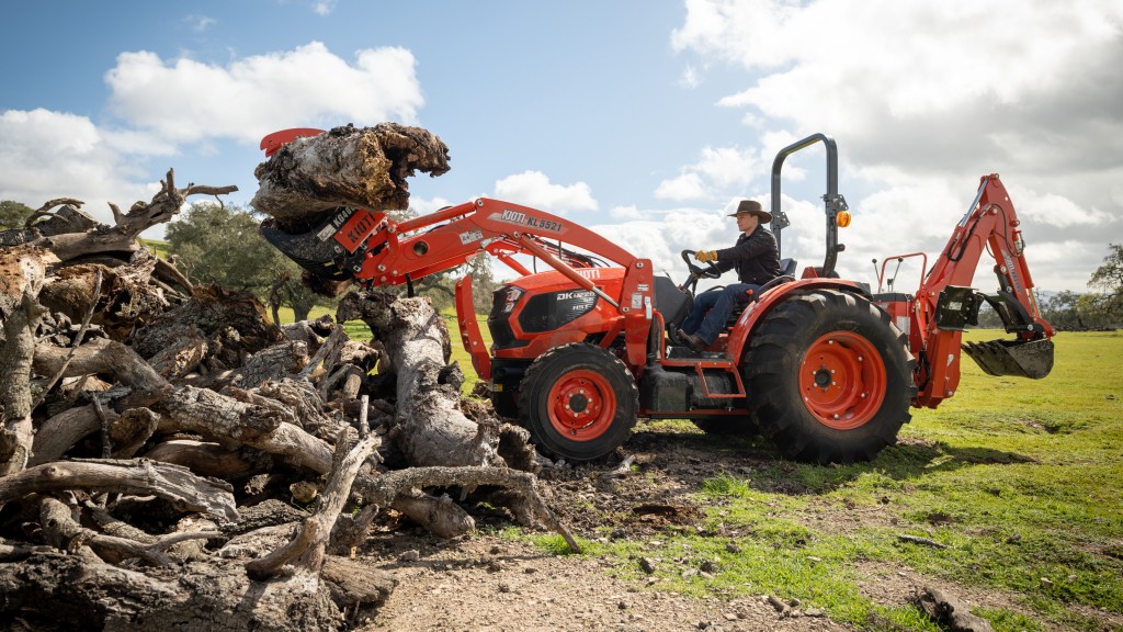 A tractor lifts up a large log