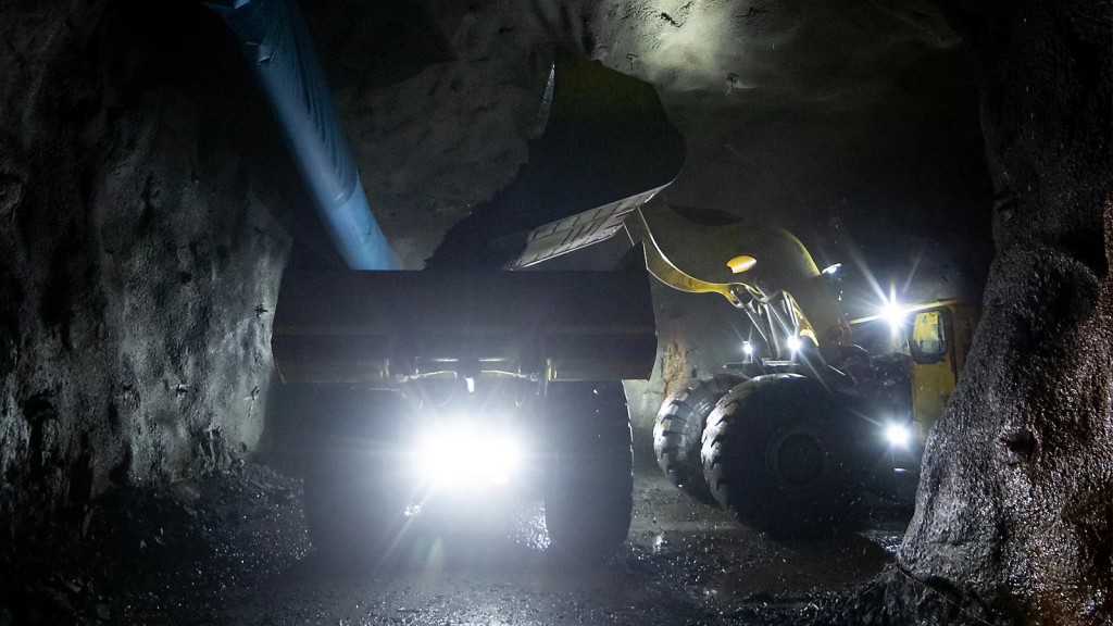 An loader fills a truck in an underground mine