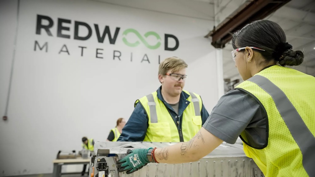 Two people work inside a battery recycling facility