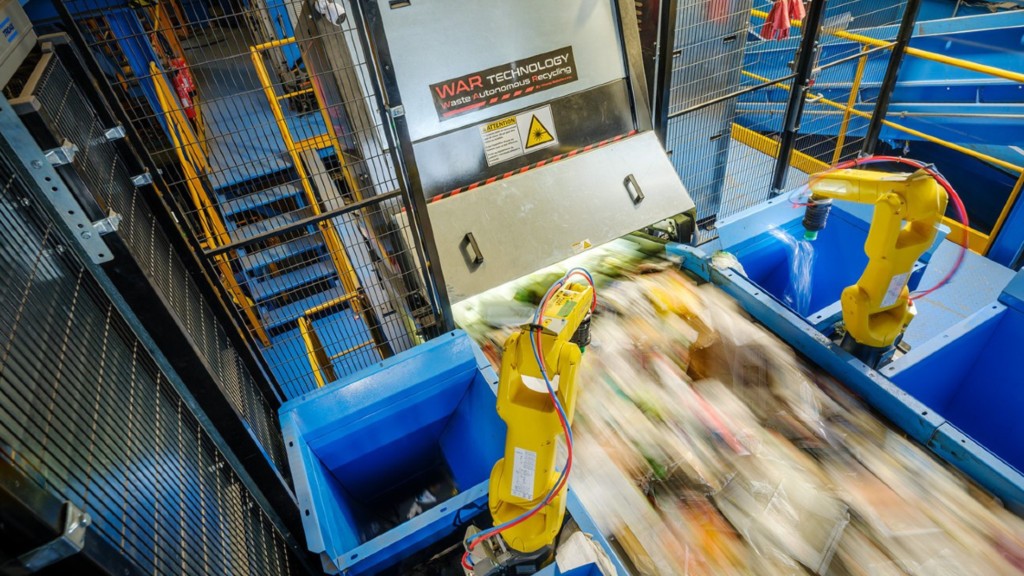 Two robots pick out recyclables on a fast-moving conveyor