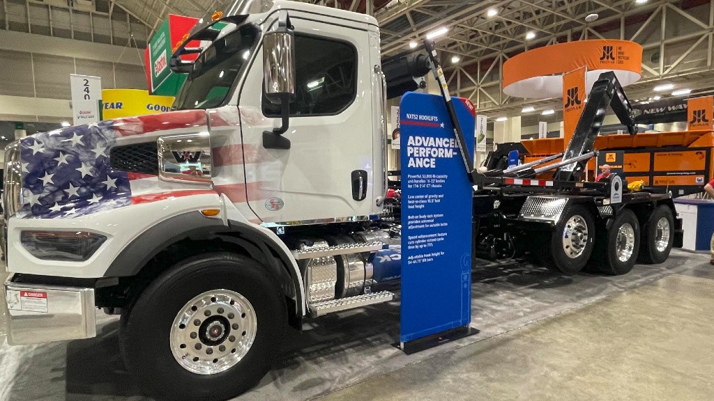 A hooklift is parked inside a trade show floor