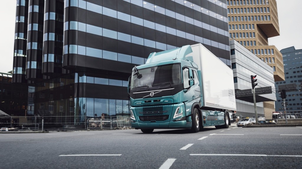 An electric truck drives down a city street