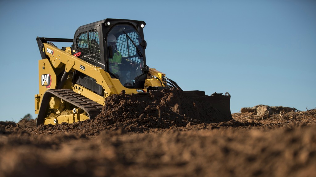 A compact track loader pushes dirt on a job site