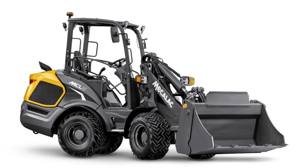 A compact wheel loader in front of a white background.