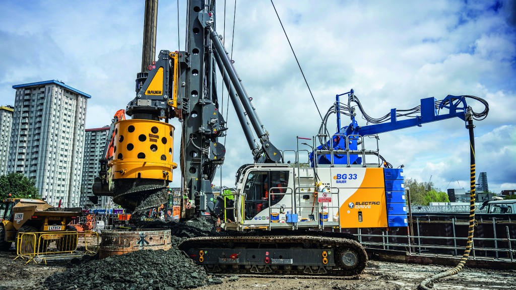 An electric drill rig operates on an urban job site