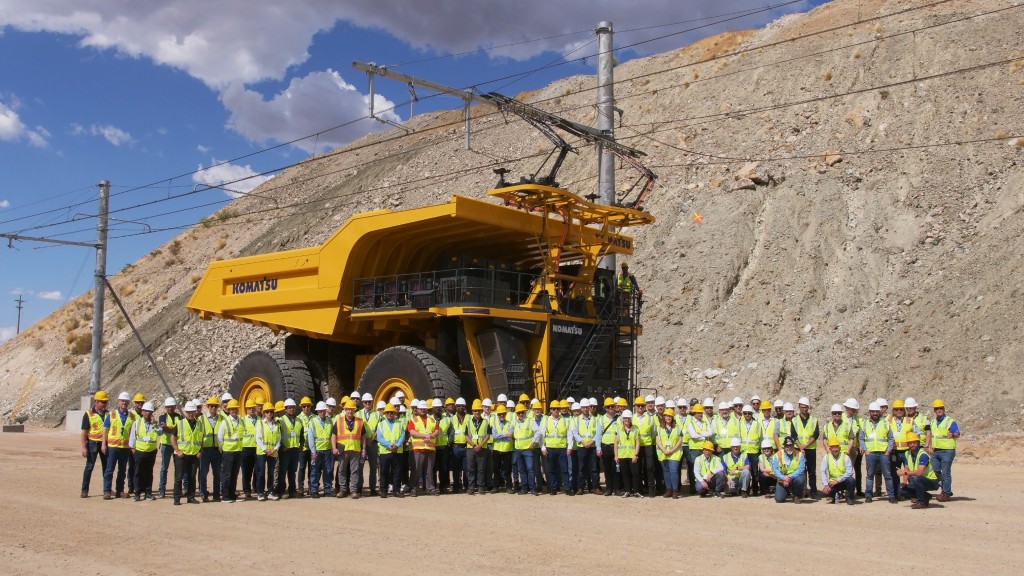 Members of Komatsu's GHG Alliance stand near an EVX battery-powered haul truck.