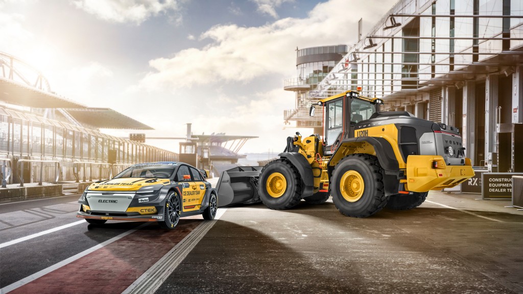 A racecar and a wheel loader are parked on a motorsports track