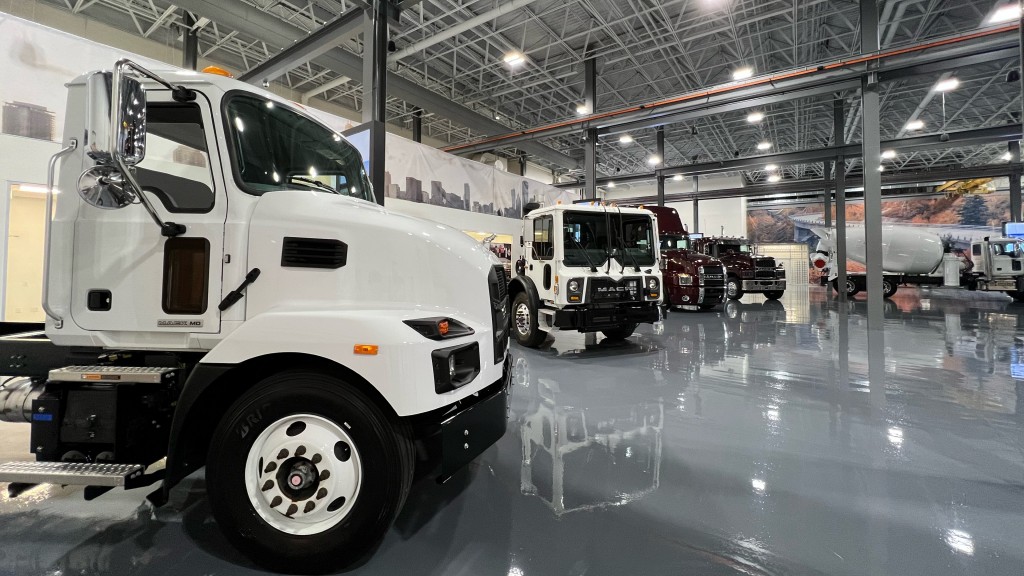 Multiple Mack trucks sit on a showroom floor