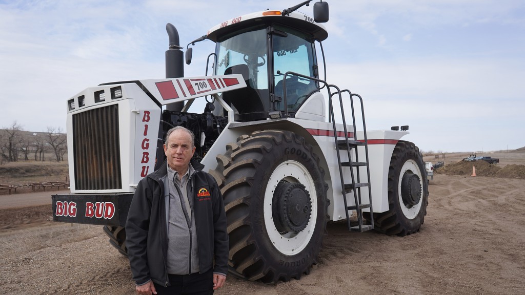 A man standing in front of a large white tractor