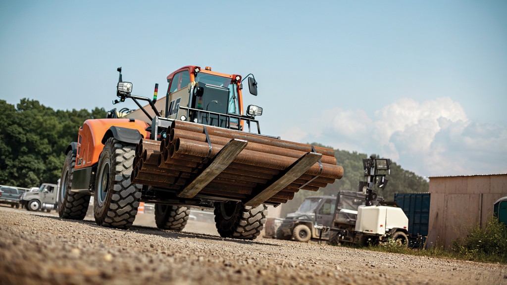 A telehandler carries pipes around on a job site