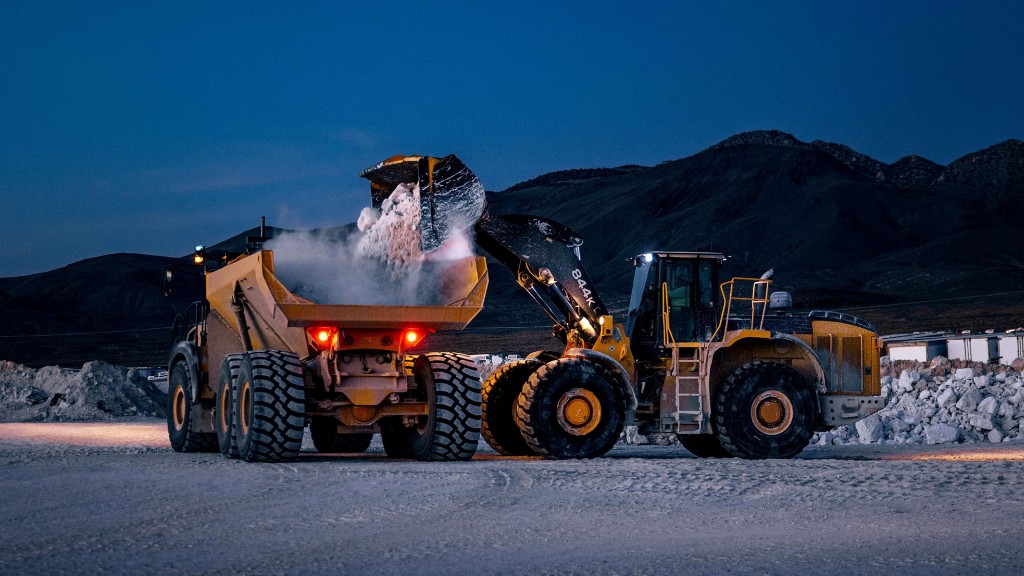 A wheel loader loading an ADT at sunset