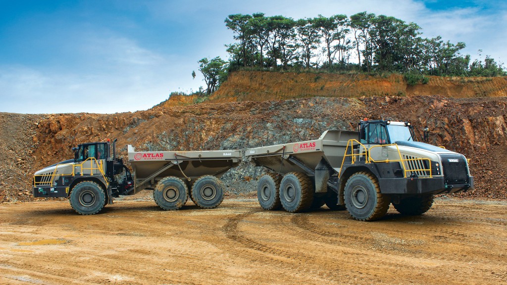 Two articulated haulers are parked at a quarry