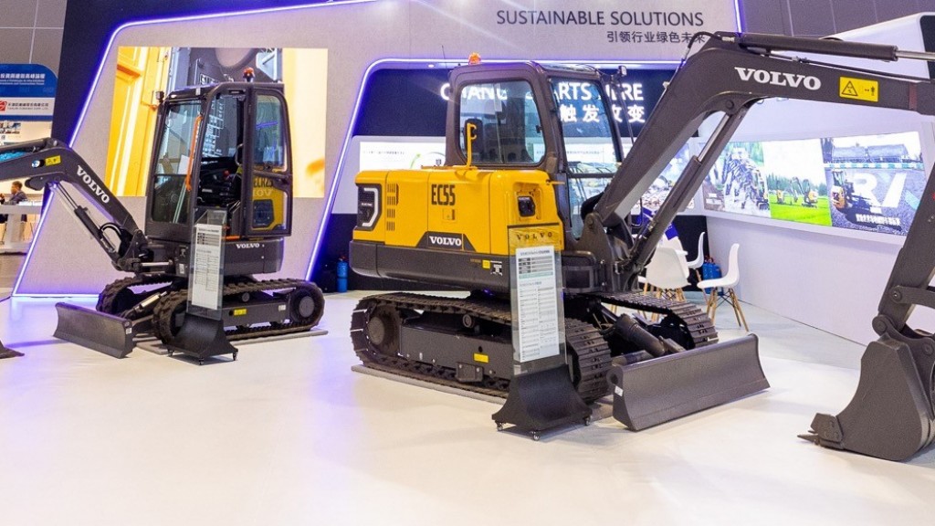 Two small excavators in a trade show display.