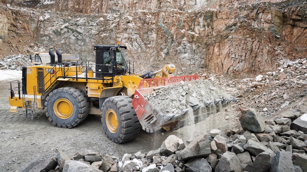 A wheel loader lifts up a bucket full of rock