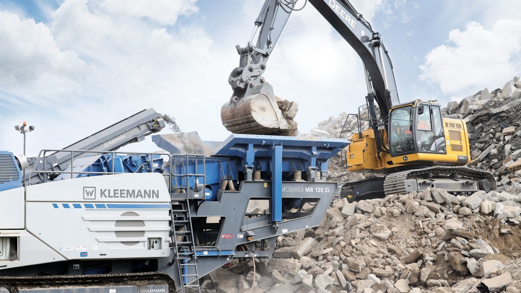 An impact crusher being loaded by an excavator.