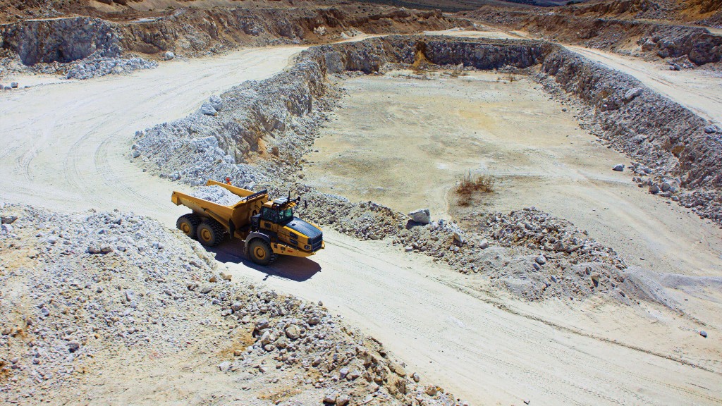 An articulated dump truck on a road around a rock pit.