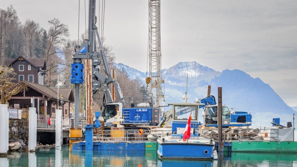A drill rig behind boats on a lake.