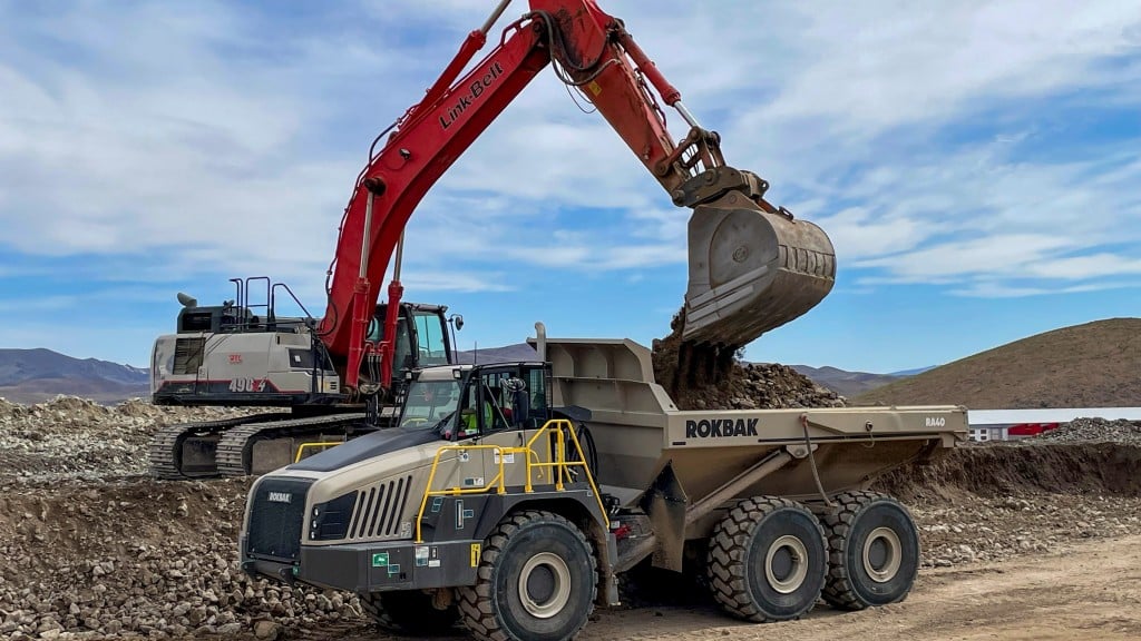 An excavator fills an articulated hauler