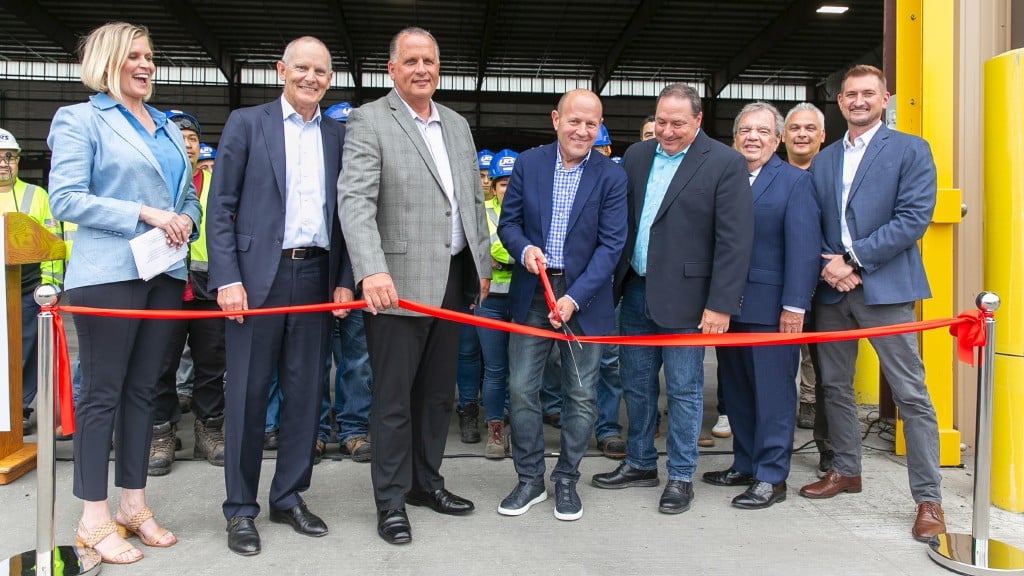 A group of people cut the ribbon at a grand opening event