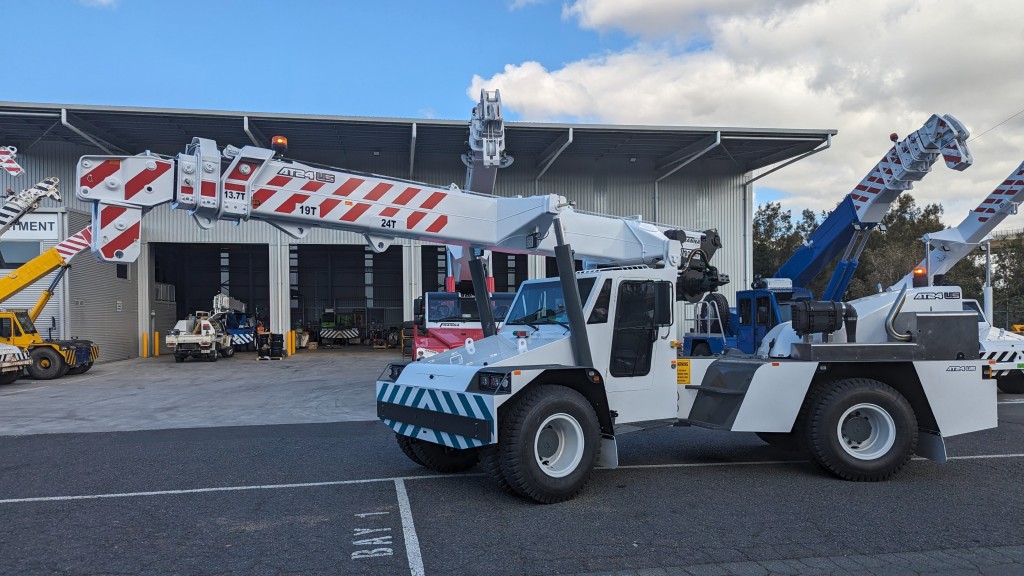 A pick and carry crane parked outside a facility