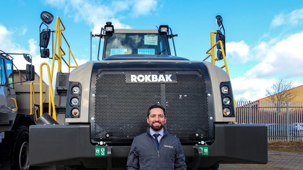 A man standing in front of a large truck.