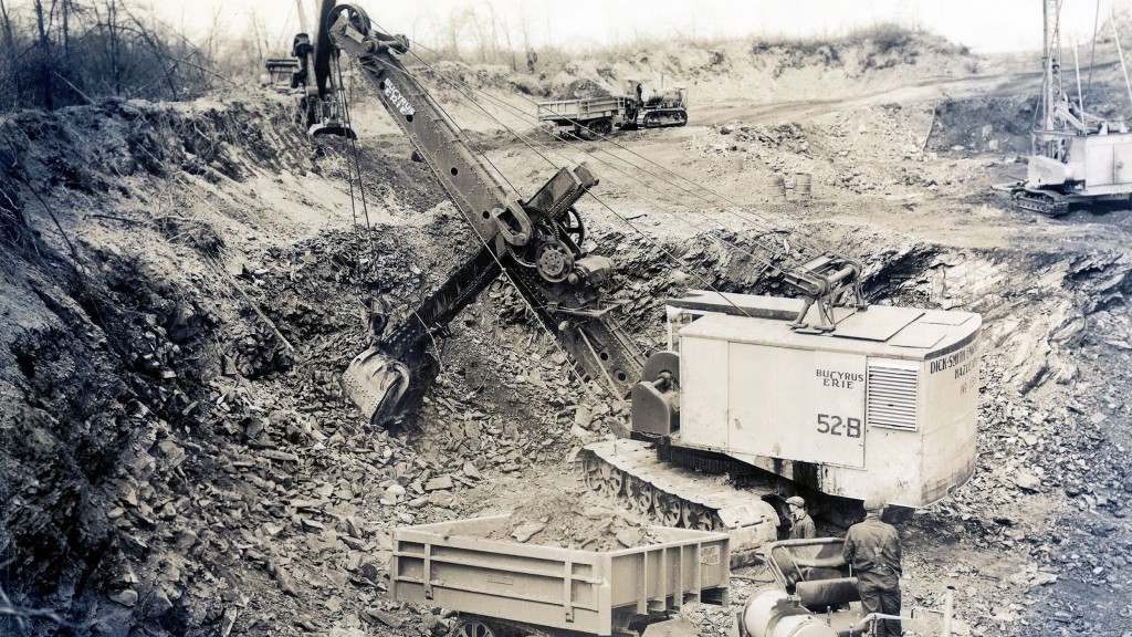 A black and white image of a large shovel working in a rock quarry.