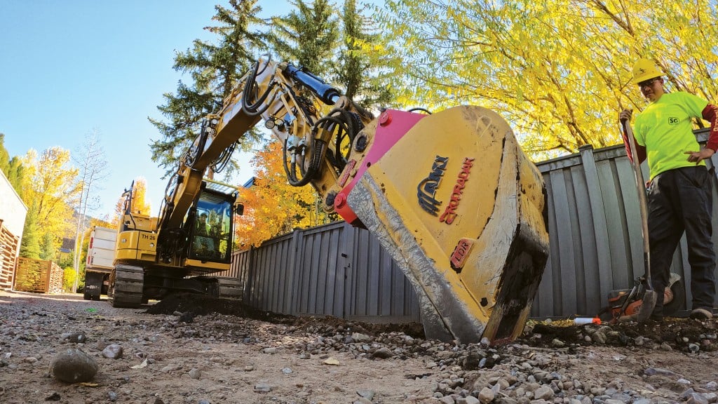 An excavator scans the ground with a bucket outfitted with GPR technology