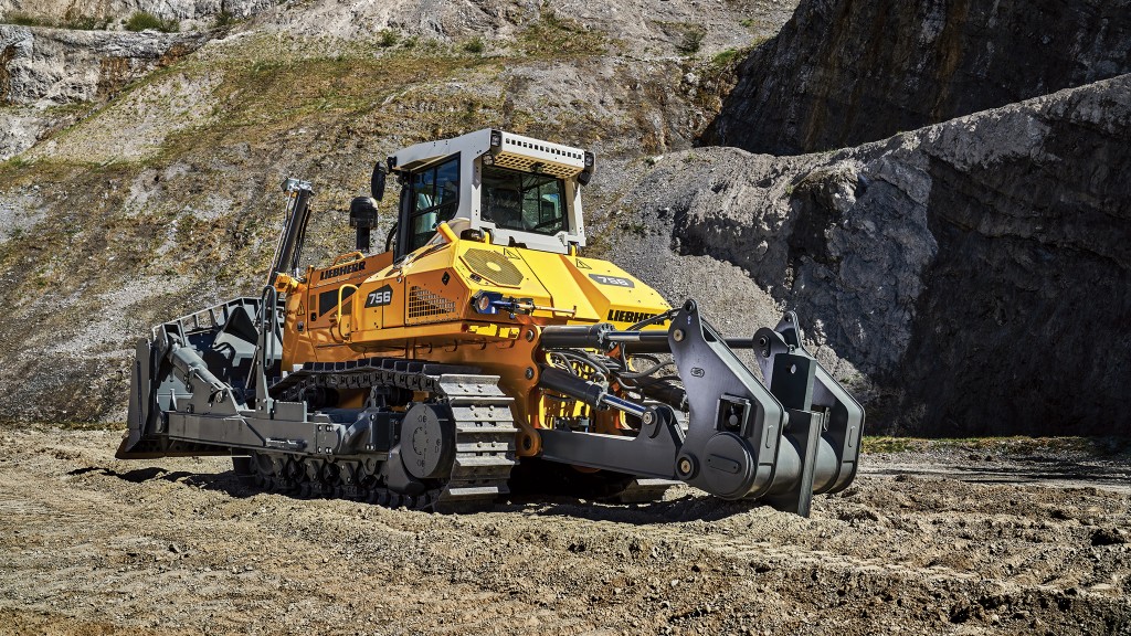 A dozer drives down a dirt road