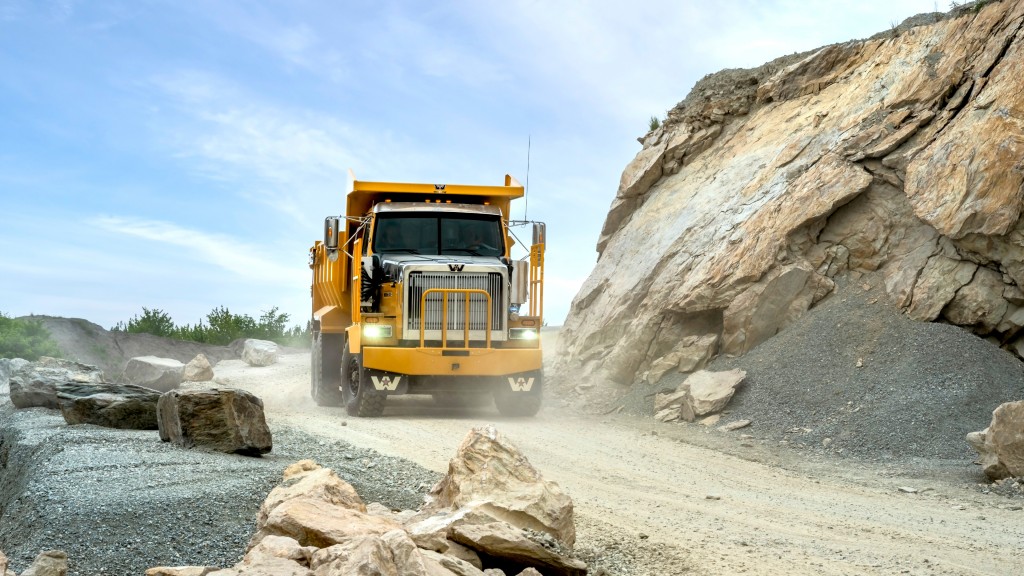 A mining truck drives down a dirt road