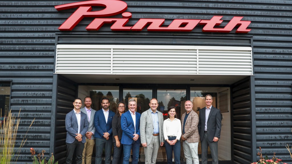 A group of people stand outside a PRINOTH facility