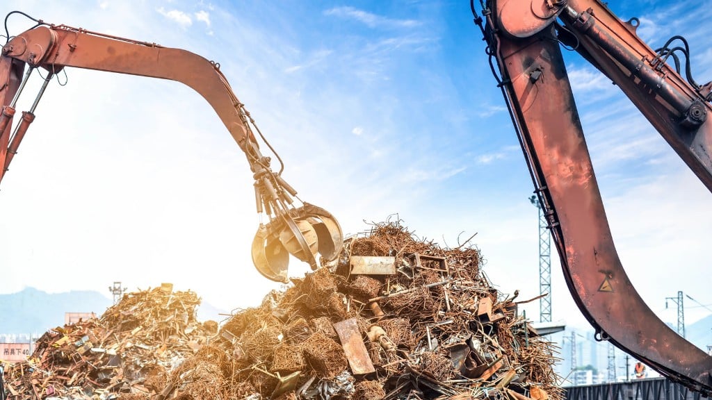 A material handler grabs scrap metal in a recycling yard