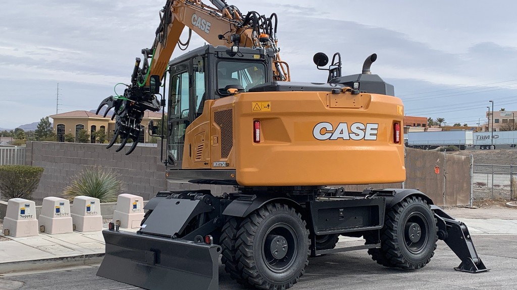 A wheeled excavator working next to a road.