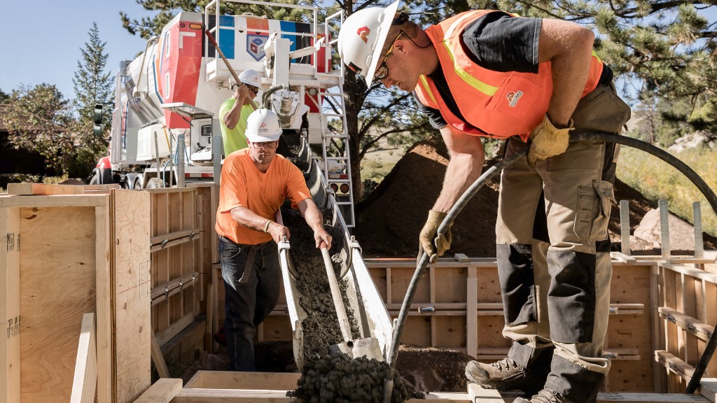 Workers lay concrete on a job site